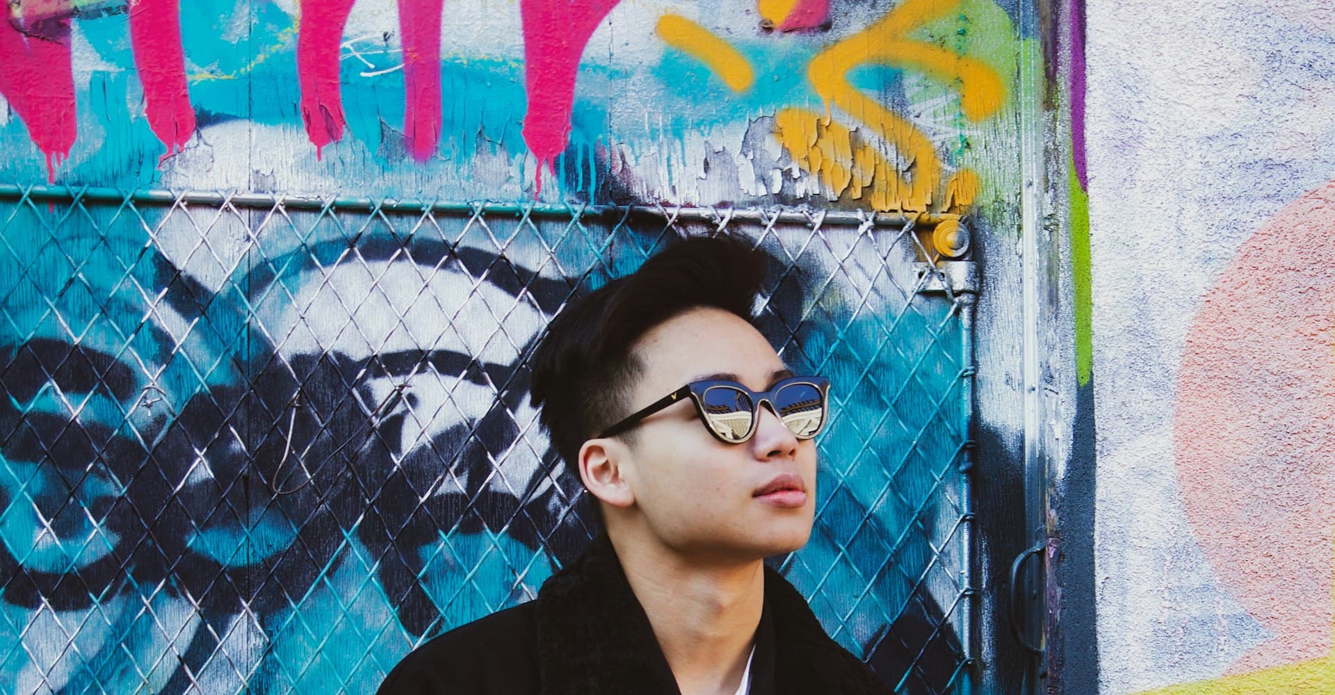 Man in a black zip-up jacket and sunglasses