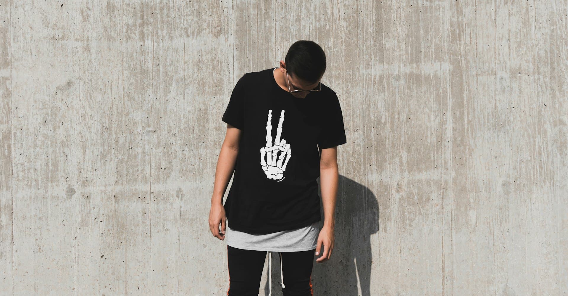 Man in an oversized t-shirt looking down on a city street